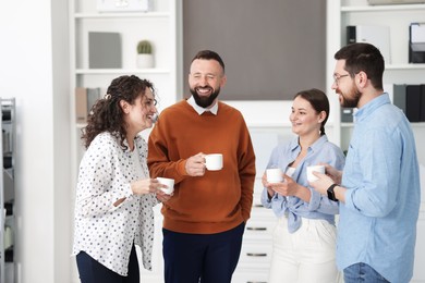 Photo of Colleagues chatting during coffee break in office