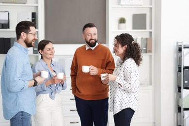 Photo of Colleagues chatting during coffee break in office