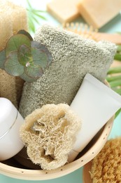 Photo of Loofah sponges, cosmetic products, towel and floral decor on table, above view