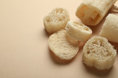 Photo of Natural loofah sponges on beige background, above view. Space for text