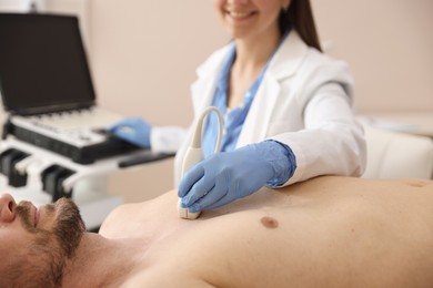 Photo of Sonographer conducting ultrasound examination of man's heart in clinic, closeup