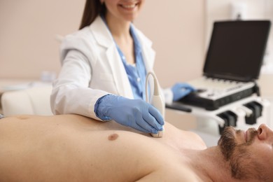 Photo of Sonographer conducting ultrasound examination of man's heart in clinic, closeup