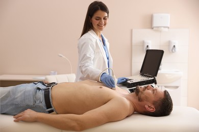 Photo of Sonographer conducting ultrasound examination of man's heart in clinic