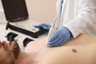 Photo of Sonographer conducting ultrasound examination of man's heart in clinic, closeup