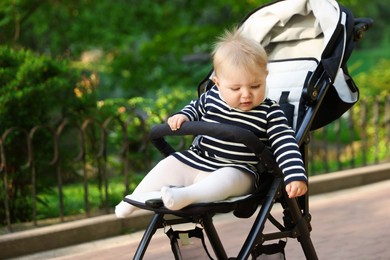 Photo of Cute little baby in stroller at park. Space for text
