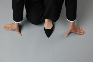 Photo of Businesswoman in starting position on gray background, top view. Space for text