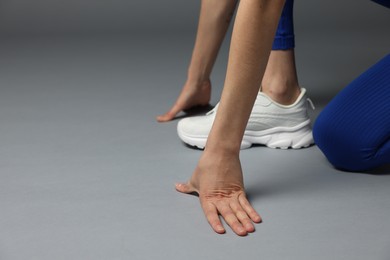 Photo of Runner in starting position on gray background, closeup. Space for text