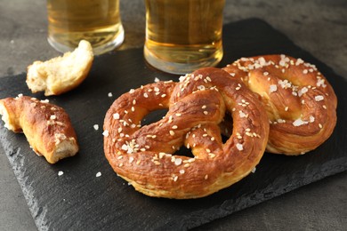 Photo of Tasty pretzels on dark textured table, closeup