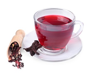Photo of Delicious hibiscus tea in glass cup, dry roselle sepals and scoop isolated on white