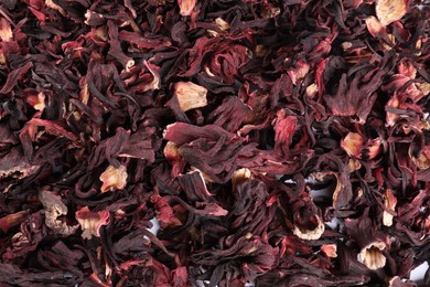 Photo of Hibiscus tea. Dried roselle sepals as background, top view