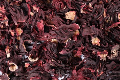 Photo of Hibiscus tea. Dried roselle sepals as background, top view