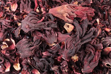 Photo of Hibiscus tea. Dried roselle sepals as background, top view