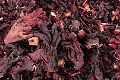 Photo of Hibiscus tea. Dried roselle sepals as background, top view