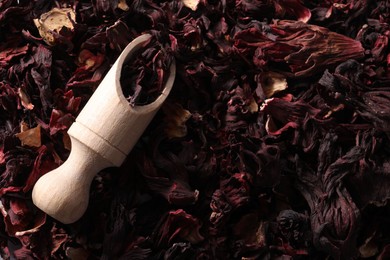 Photo of Hibiscus tea. Wooden scoop with dried roselle sepals, top view