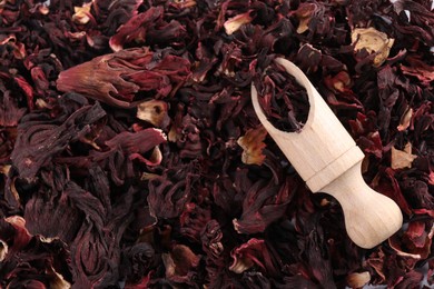 Photo of Hibiscus tea. Wooden scoop with dried roselle sepals, top view