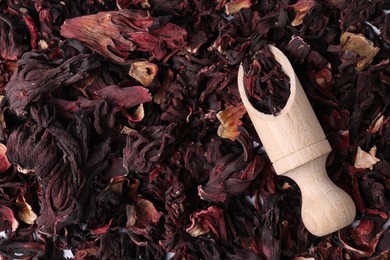 Photo of Hibiscus tea. Wooden scoop with dried roselle sepals, top view