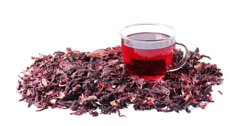 Photo of Delicious hibiscus tea in glass cup and dry roselle sepals isolated on white