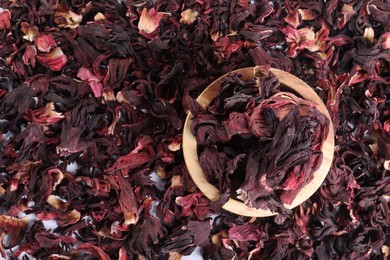 Photo of Hibiscus tea. Wooden bowl with dried roselle sepals on table, top view