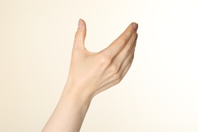 Photo of Woman holding something in hand on beige background, closeup