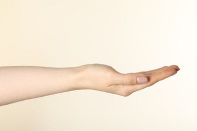 Photo of Woman holding something in hand on beige background, closeup