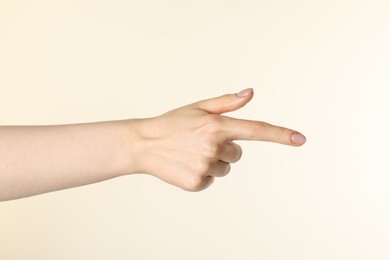 Photo of Woman holding something in hand on beige background, closeup