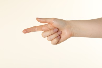 Photo of Woman holding something in hand on beige background, closeup
