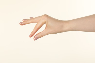 Photo of Woman holding something in hand on beige background, closeup