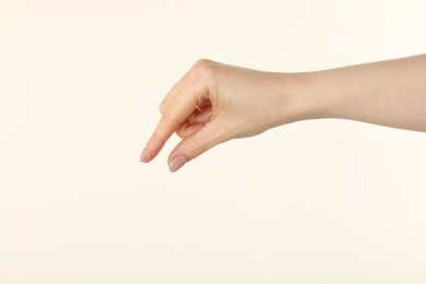 Photo of Woman holding something in hand on beige background, closeup