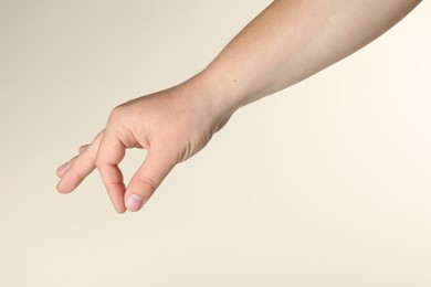 Photo of Man holding something in hand on beige background, closeup