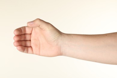 Photo of Man holding something in hand on beige background, closeup