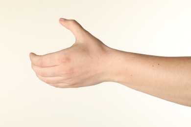 Photo of Man holding something in hand on beige background, closeup