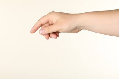 Photo of Man holding something in hand on beige background, closeup