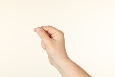 Photo of Man holding something in hand on beige background, closeup