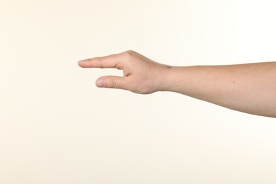 Photo of Man holding something in hand on beige background, closeup