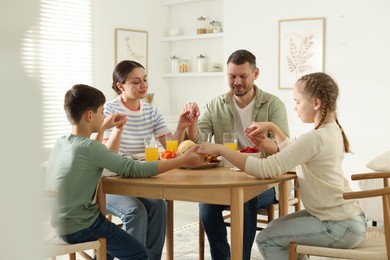 Photo of Family praying together before dinner at table indoors