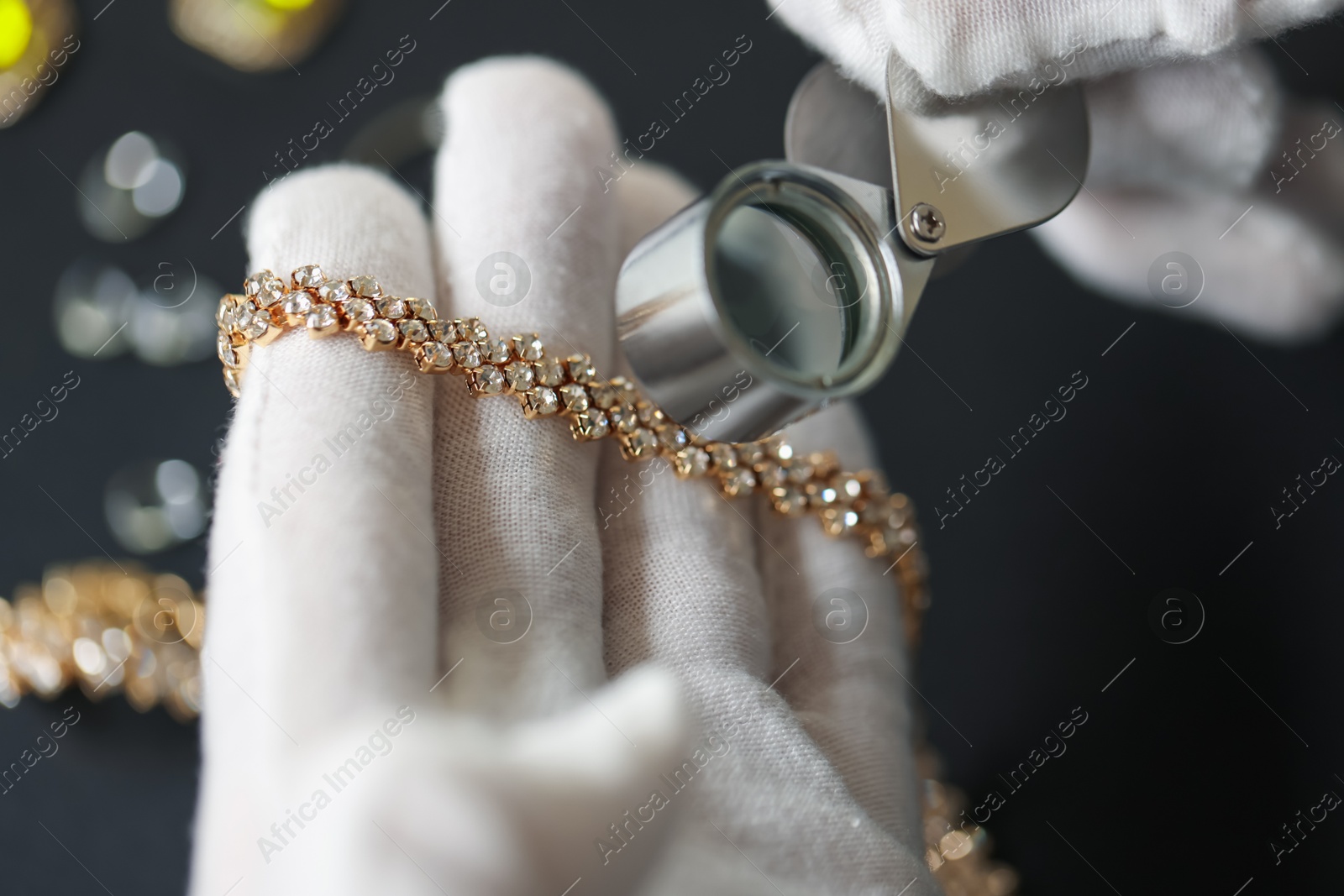 Appraiser evaluating luxury jewelry at table indoors, closeup Photo of Appraiser evaluating luxury jewelry at table indoors, closeup