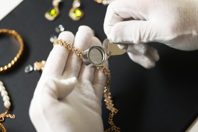 Photo of Appraiser evaluating luxury jewelry at table indoors, above view