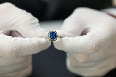 Photo of Appraiser working with luxury ring at table, closeup