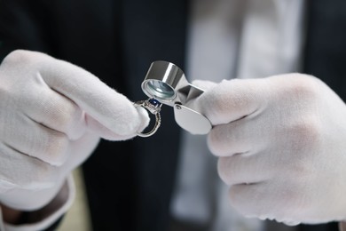 Photo of Appraiser with loupe evaluating luxury ring, closeup