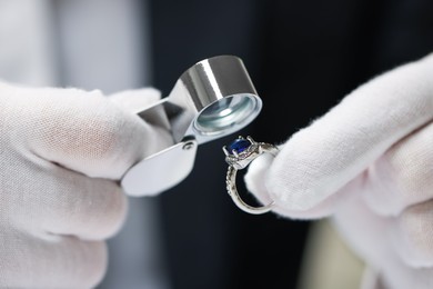 Photo of Appraiser with loupe evaluating luxury ring, closeup