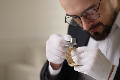 Photo of Appraiser with loupe evaluating luxury bracelet indoors, space for text