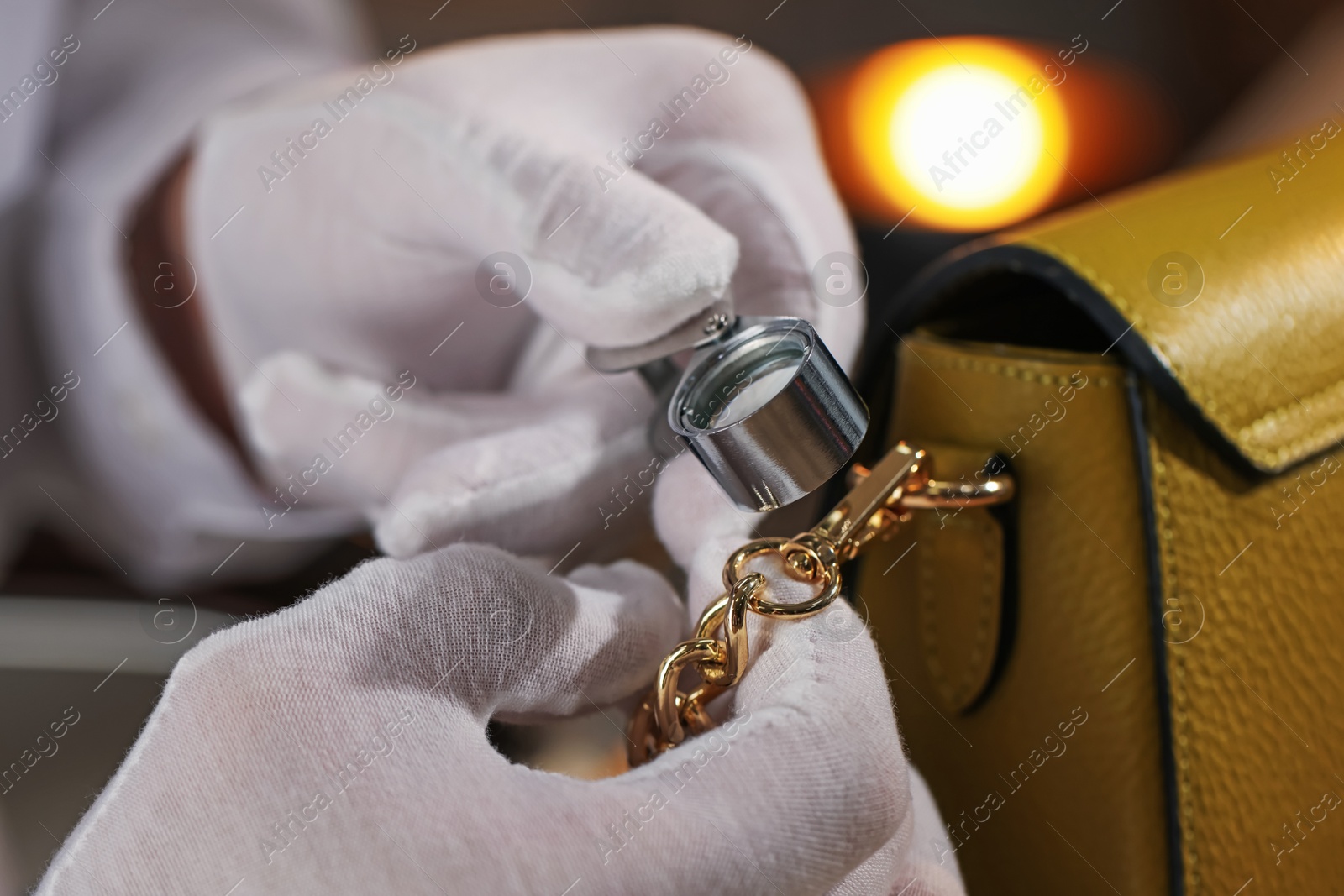 Appraiser with loupe evaluating bag indoors, closeup Photo of Appraiser with loupe evaluating bag indoors, closeup