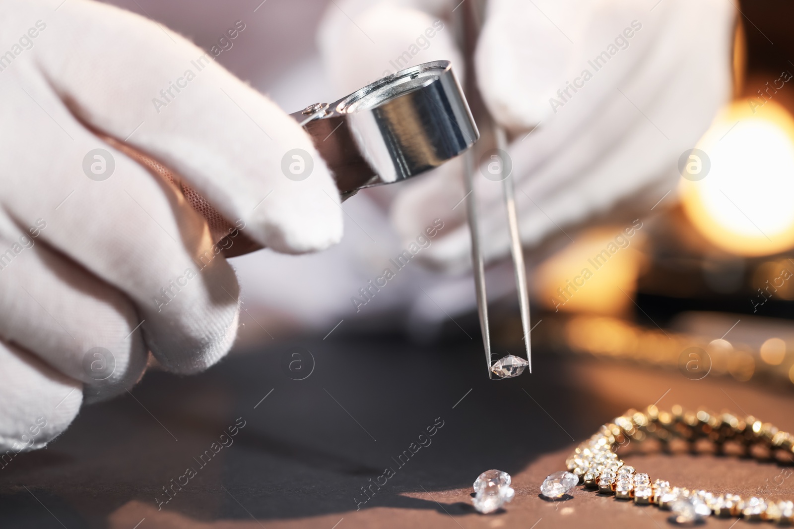 Appraiser with loupe evaluating gemstone at table indoors, closeup Photo of Appraiser with loupe evaluating gemstone at table indoors, closeup
