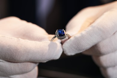 Photo of Appraiser working with luxury ring indoors, closeup