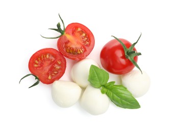 Photo of Tasty mozzarella cheese balls, tomatoes and basil isolated on white, top view