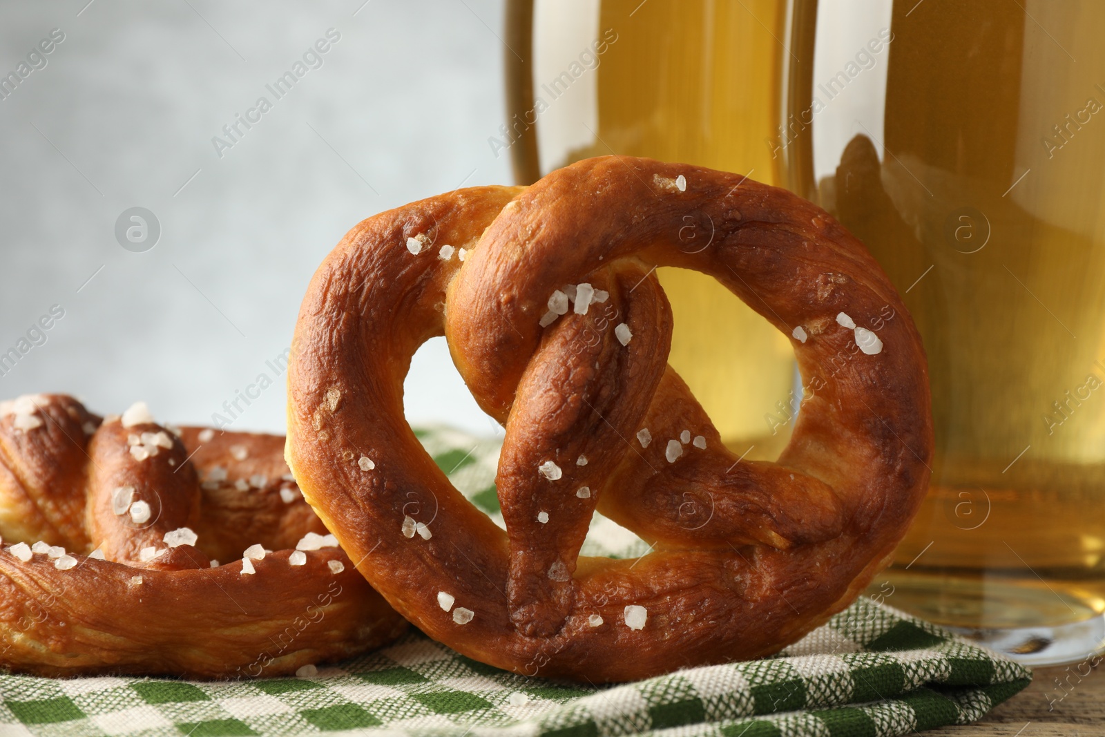 Tasty pretzels and glasses of beer on table against grey background, closeup Photo of Tasty pretzels and glasses of beer on table against grey background, closeup