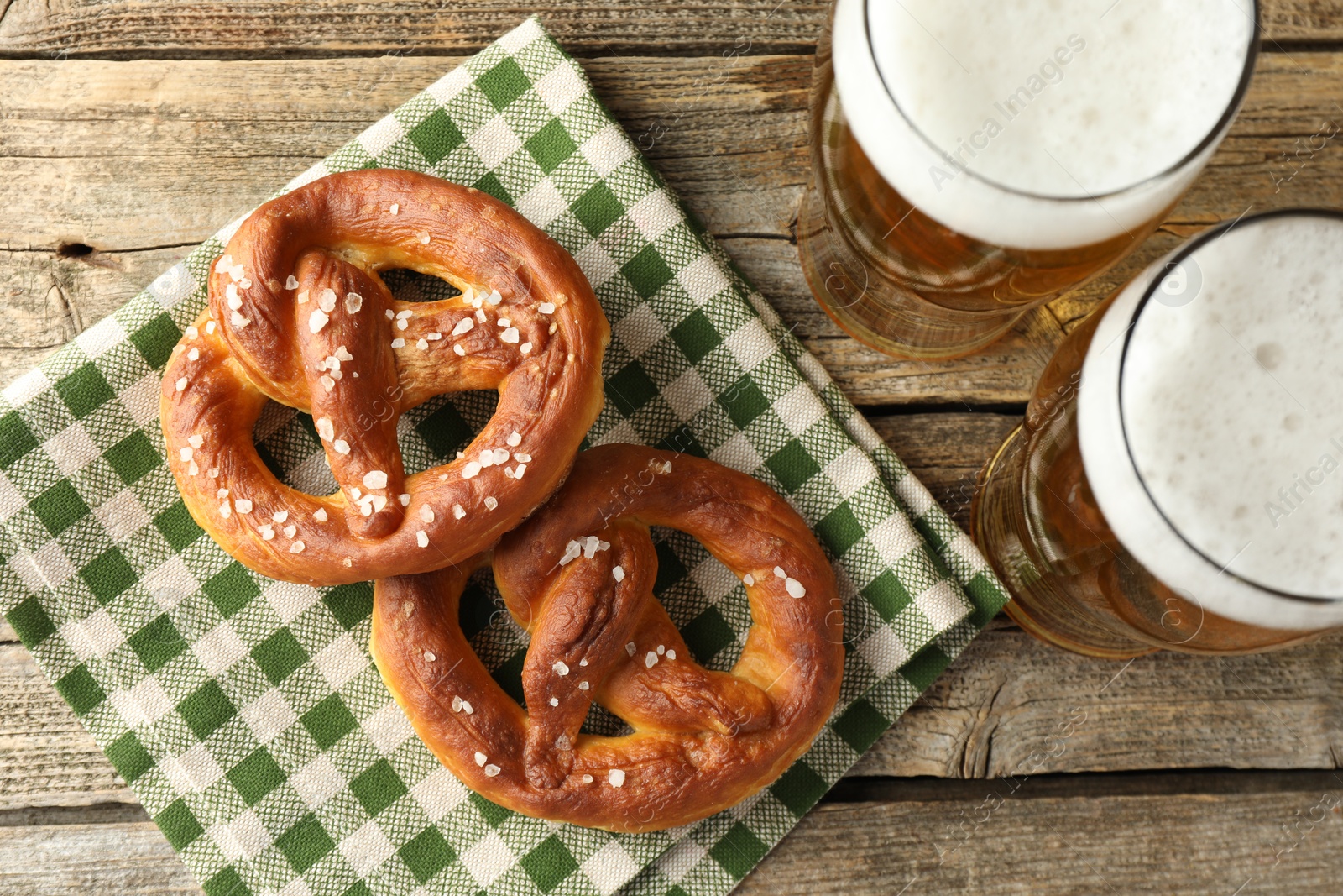 Tasty pretzels and glasses of beer on wooden table, flat lay Photo of Tasty pretzels and glasses of beer on wooden table, flat lay