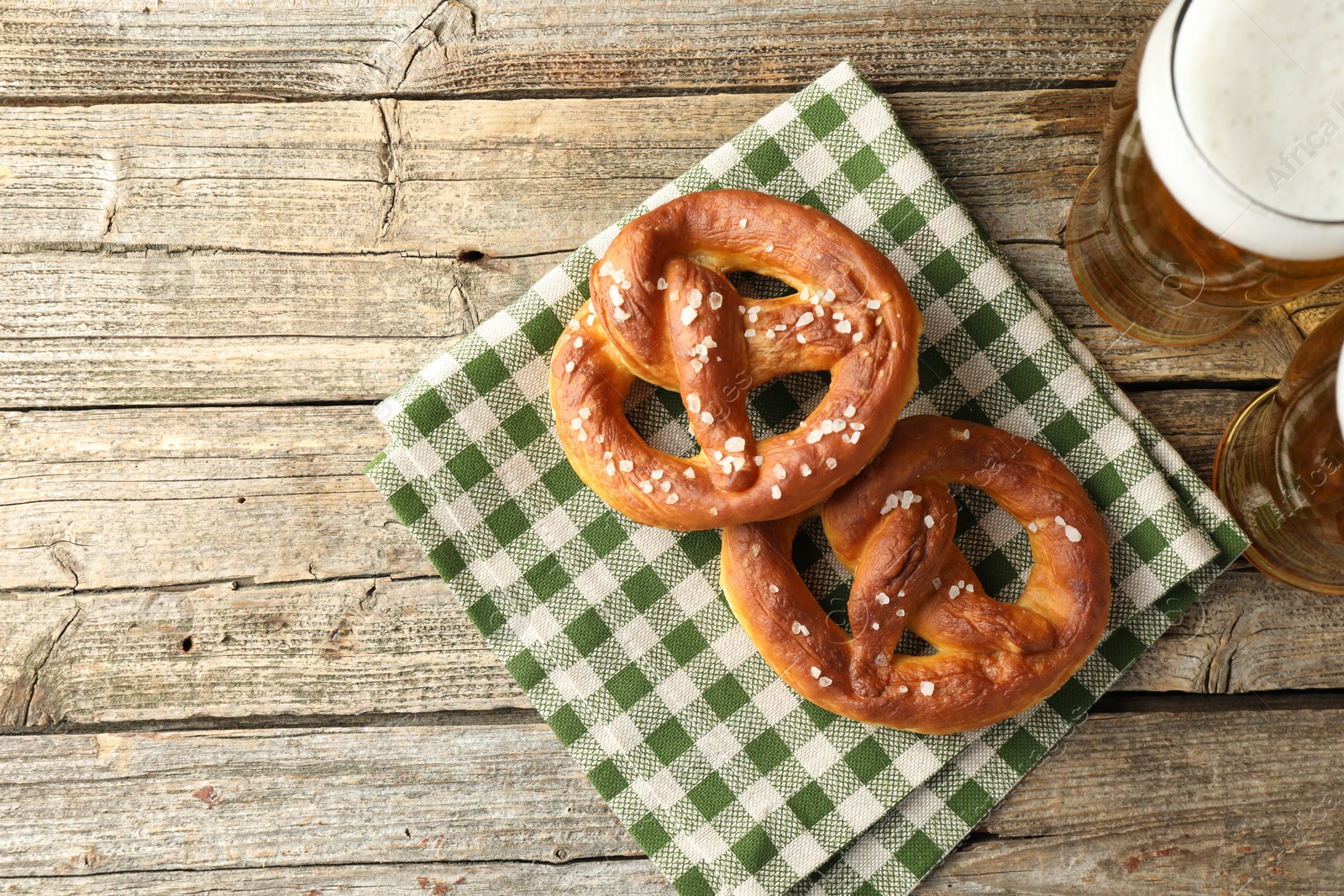 Tasty pretzels and glasses of beer on wooden table, flat lay. Space for text Photo of Tasty pretzels and glasses of beer on wooden table, flat lay. Space for text