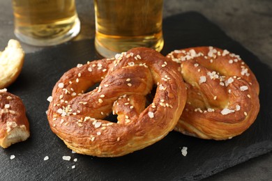 Photo of Tasty pretzels on dark textured table, closeup
