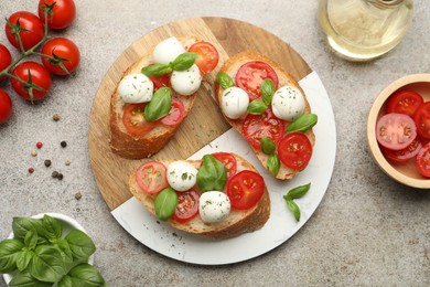 Photo of Tasty sandwiches with mozzarella cheese balls, tomato and basil on grey table, flat lay